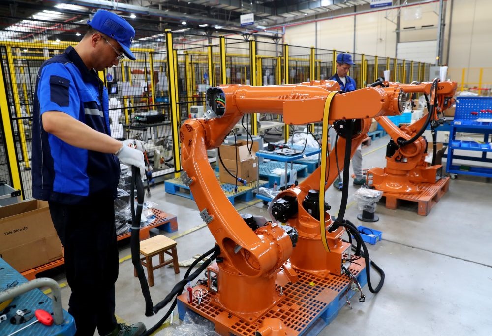 工作人員在上海新時(shí)達(dá)機(jī)器人有限公司位于嘉定的智能工廠內(nèi)忙碌（2024年5月23日攝）。新華社記者 龔兵 攝