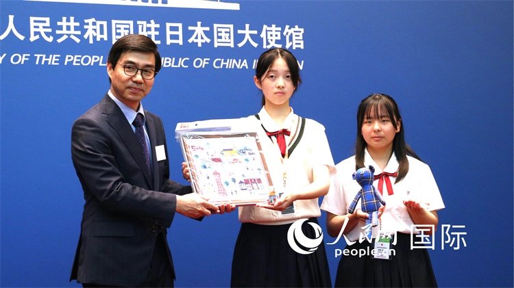日本小大使向中國駐日本大使館臨時代辦施泳贈送當?shù)靥厣Y品。人民網(wǎng) 許可攝