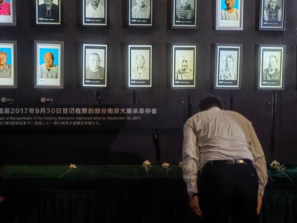 7月18日，人們向離世的南京大屠殺幸存者獻(xiàn)花、鞠躬。新華社記者邱冰清 攝