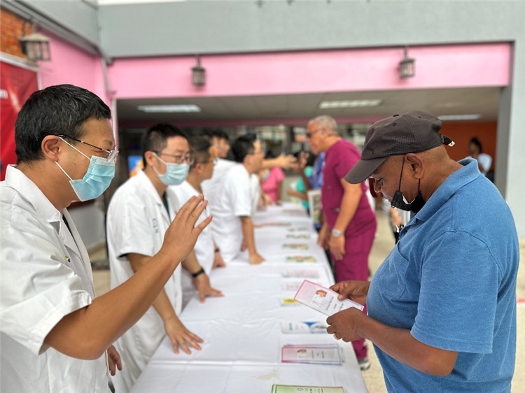 援圭醫(yī)療隊隊員們在啟動儀式上為當?shù)孛癖姺职l(fā)宣傳手冊。中國援助圭亞那醫(yī)療隊供圖