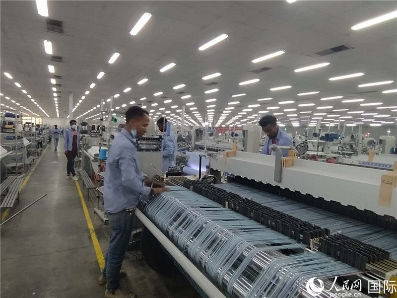 無錫金茂埃塞面料廠車間內(nèi)，當?shù)毓と苏谝唤z不茍地作業(yè)。人民網(wǎng)記者 黃培昭攝