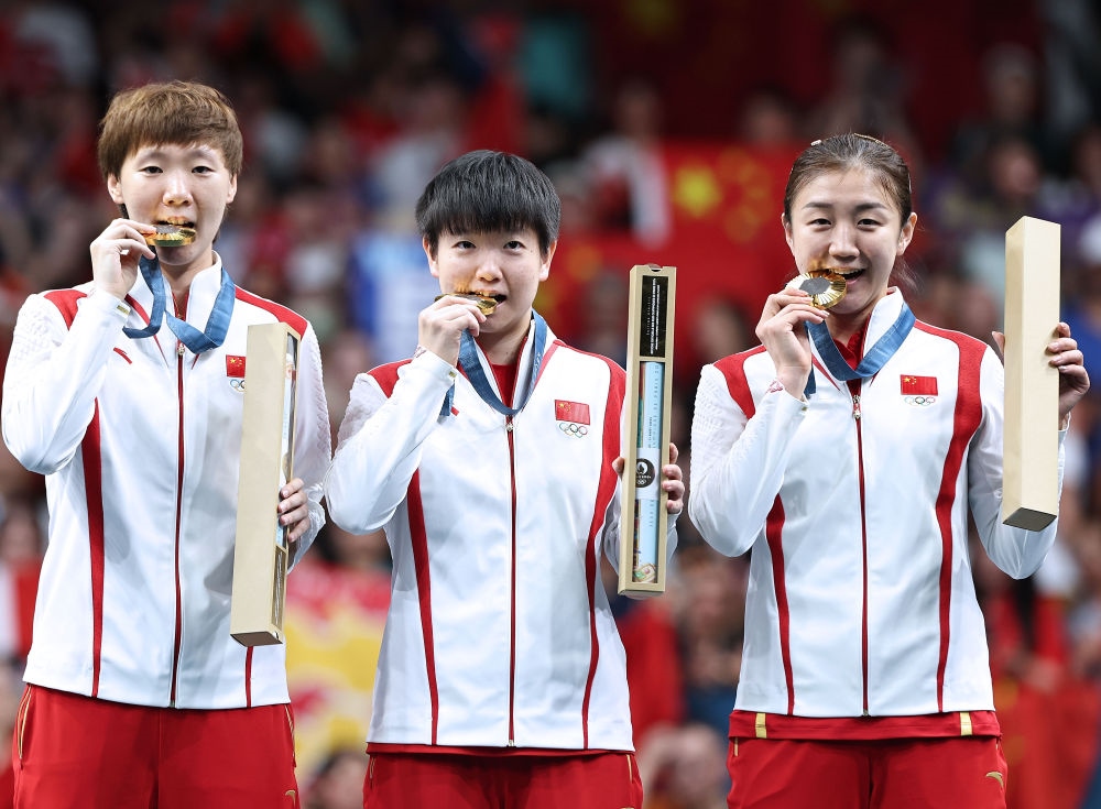 冠軍中國隊選手王曼昱、孫穎莎、陳夢（從左至右）在巴黎奧運會乒乓球女子團體頒獎儀式上（2024年8月10日攝）。新華社記者 王東震 攝
