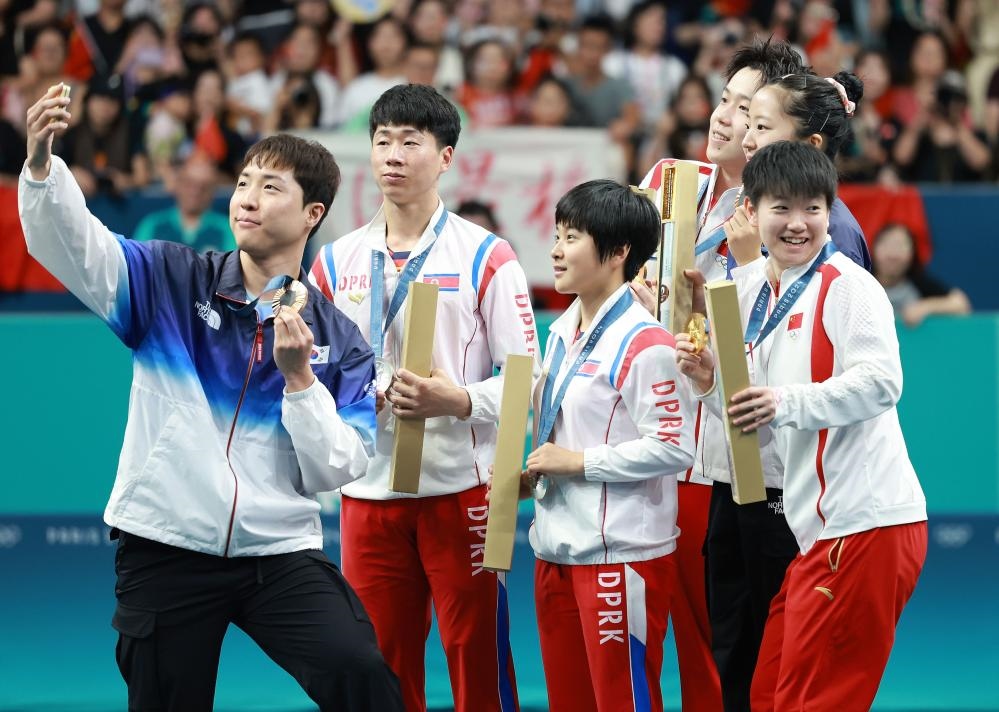 冠軍中國組合王楚欽（右三）/孫穎莎（右一）、亞軍朝鮮組合李正植（左二）/金琴英（左三）、季軍韓國組合林鐘勛（左一）/申裕斌在巴黎奧運會乒乓球混雙頒獎儀式上合影（2024年7月30日攝）。新華社記者 劉續(xù) 攝