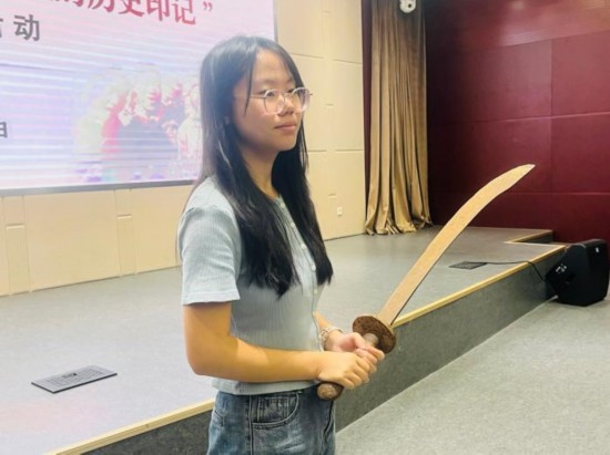 圖為南開(kāi)大學(xué)社會(huì)實(shí)踐隊(duì)學(xué)生代表呼月紅在學(xué)術(shù)交流活動(dòng)現(xiàn)場(chǎng)，展示河間調(diào)研行中獲贈(zèng)的一戰(zhàn)華工蔡世春曾使用過(guò)的一把大刀。林卓瑋 攝