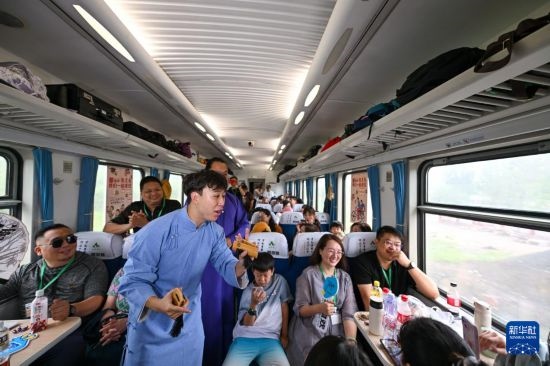 9月7日，相聲演員在S910列車上為旅客表演快板。