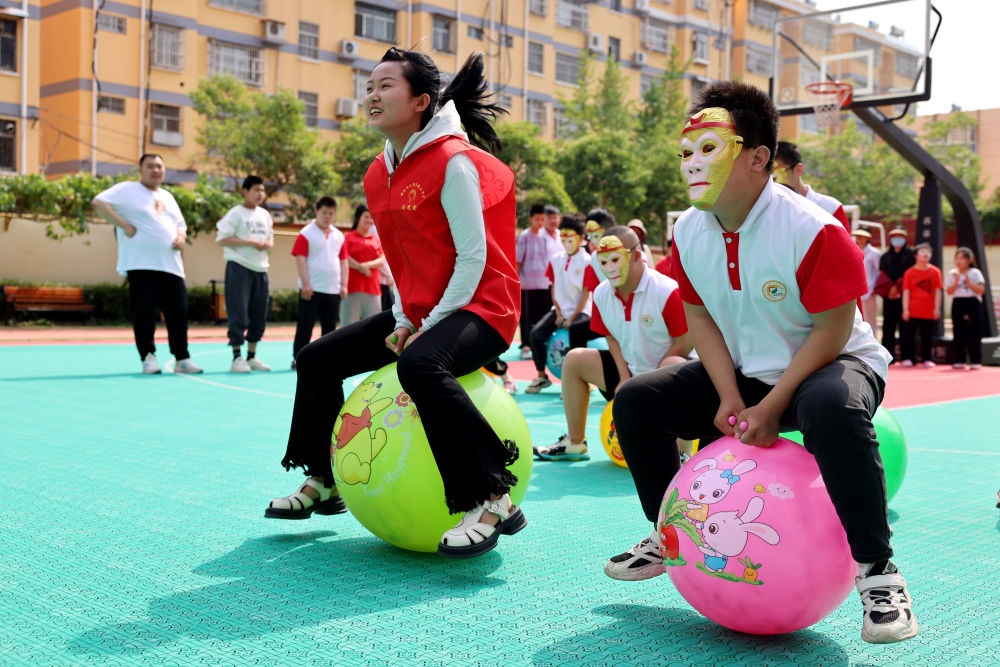 2024年5月17日，在山東省棗莊市市中區(qū)特殊教育中心，青年志愿者與智力障礙學(xué)生一起做游戲。新華社發(fā)（孫中喆攝）