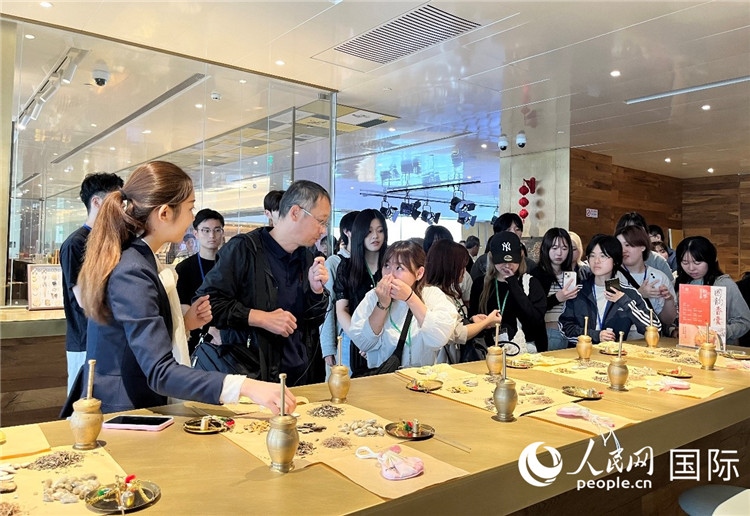 1. 日中友好協(xié)會青年代表團(tuán)一行學(xué)習(xí)中醫(yī)香囊制作工序。（人民網(wǎng)記者陳思 攝）