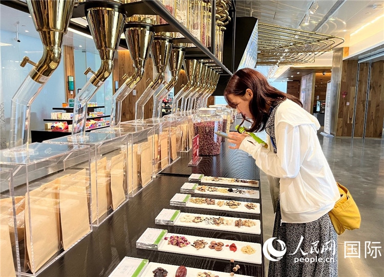 4. 代表團(tuán)團(tuán)員對新中式茶飲的食材充滿興趣。（人民網(wǎng)記者陳思 攝）