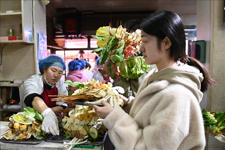 游客挑選好麻辣燙菜品后排隊(duì)等待加工。新華社記者 范培珅 攝