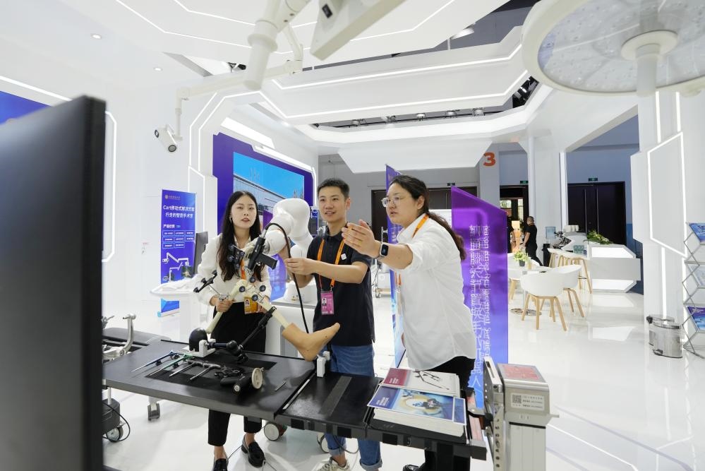9月11日，一位媒體記者（中）在2024年服貿(mào)會(huì)國家會(huì)議中心會(huì)場體驗(yàn)北京納通科技集團(tuán)有限公司的膝關(guān)節(jié)置換手術(shù)機(jī)器人。新華社記者鞠煥宗 攝