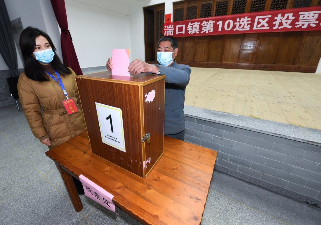 2021年12月14日，在浙江省杭州市臨安區(qū)湍口鎮(zhèn)迎豐村的基層投票點，村民在參加投票，村級監(jiān)察聯絡員監(jiān)票。新華社記者 徐昱 攝
