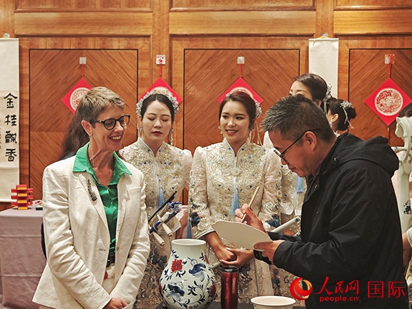 現(xiàn)場的非遺傳承人為英國觀眾展示畫技。人民網(wǎng)記者 邢雪攝