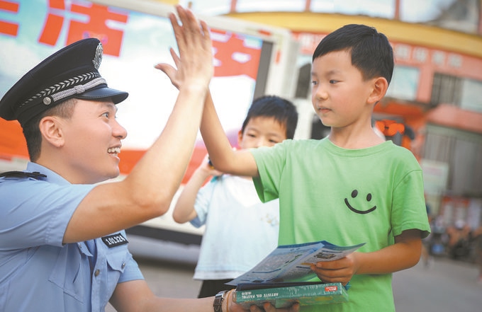 ▲7月10日，江西省吉安市公安局吉州分局組織民警深入轄區(qū)開展安全宣傳，民警向小朋友講解防溺水知識。朱文杰攝
