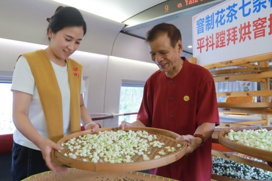 10月1日，福州市茉莉花茶窨制工藝代表性傳承人張子建與旅客在G1634次列車上制作茉莉花茶。新華社記者周義 攝