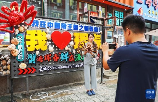 9月21日，游客在吉林省琿春市一處帝王蟹元素主題裝飾前拍照留念。新華社發(fā)