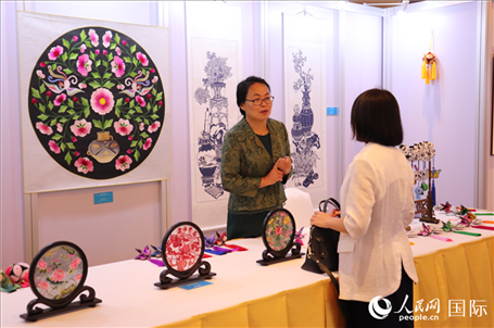 青海非遺文化傳承人向嘉賓介紹展品。人民網(wǎng)實(shí)習(xí)生姚欣可攝