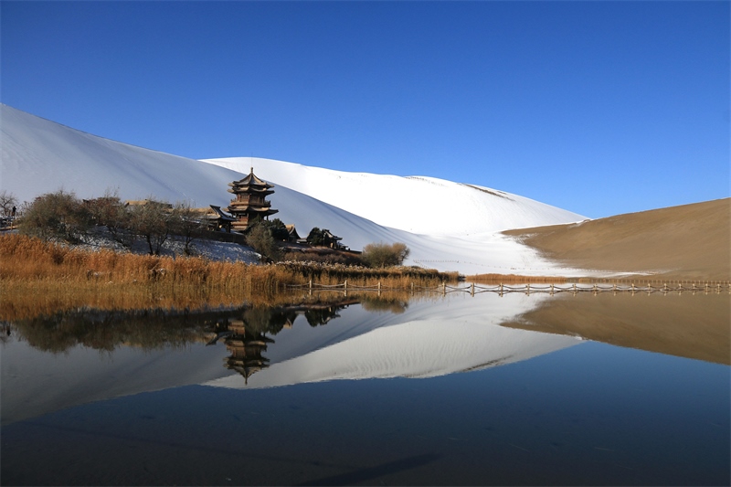 鳴沙山月牙泉景區(qū)雪景。敦煌市委宣傳部供圖，張曉亮攝