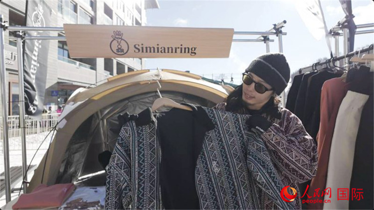 藤田周正在展示自己設(shè)計的滑雪服。人民網(wǎng)記者 袁蒙攝