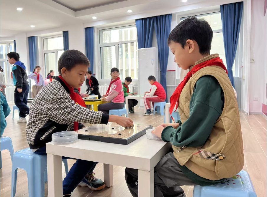 學(xué)生們?cè)谏傧汝?duì)大廳下圍棋。人民網(wǎng) 白炅攝
