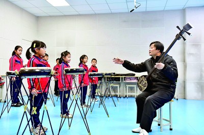 圖為12月30日，在惠民縣胡集鎮(zhèn)第一小學(xué)，老師指導(dǎo)學(xué)生學(xué)習(xí)西河大鼓。新華社記者 郭緒雷攝