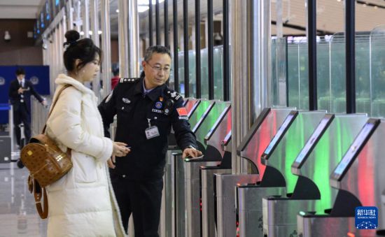 1月2日，大興機場邊檢站警察指導旅客使用自助出境設備。新華社記者 李欣 攝
