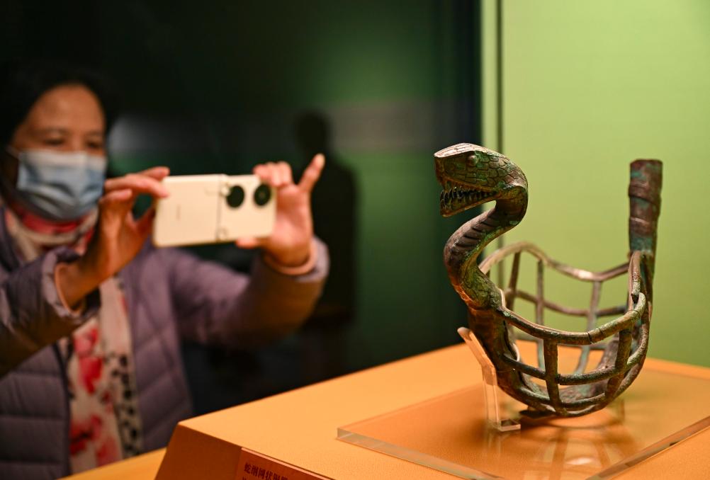1月14日，觀眾在上海博物館蛇年迎春展拍攝展品蛇綱網(wǎng)狀銅器。新華社發(fā)（陳浩明攝）
