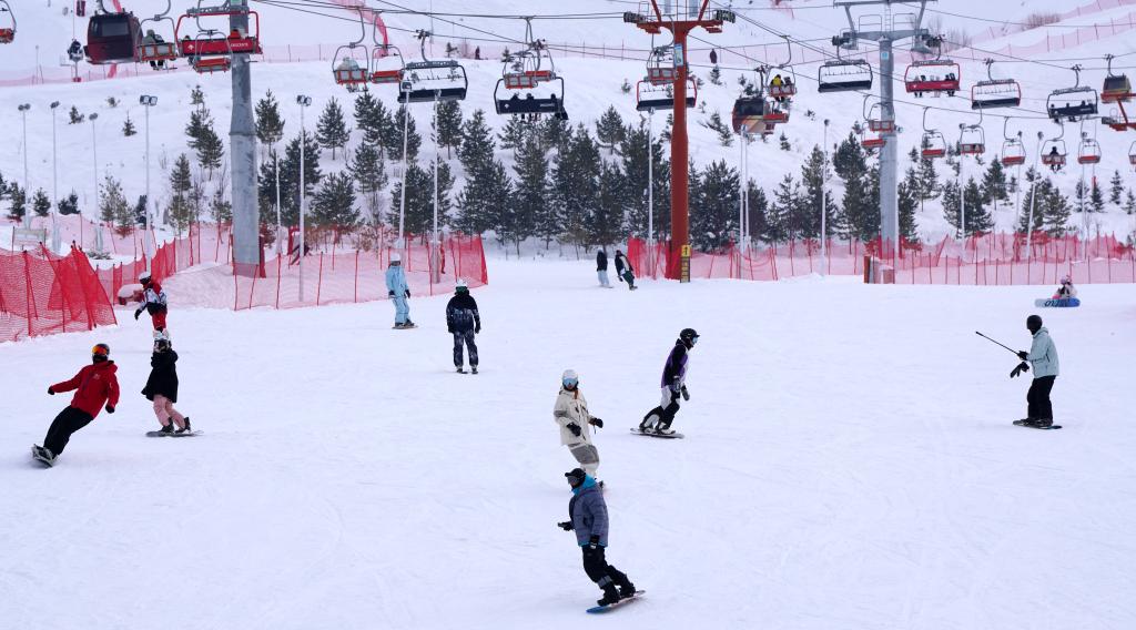2025年1月8日，滑雪愛(ài)好者在新疆阿勒泰市將軍山滑雪場(chǎng)的雪道上滑行。新華社記者 張嘯誠(chéng) 攝