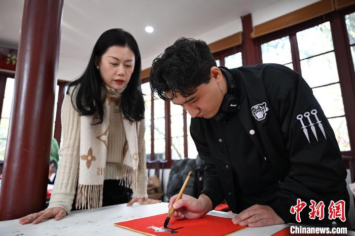 1月20日，外籍留學(xué)生在西泠印社社員李硯指導(dǎo)下寫福。當日，來自巴西、馬來西亞、加納、哈薩克斯坦的外籍留學(xué)生在浙江杭州西泠印社體驗福貼、春聯(lián)和篆刻，感受古老的中國傳統(tǒng)文化。中新社記者 王剛 攝