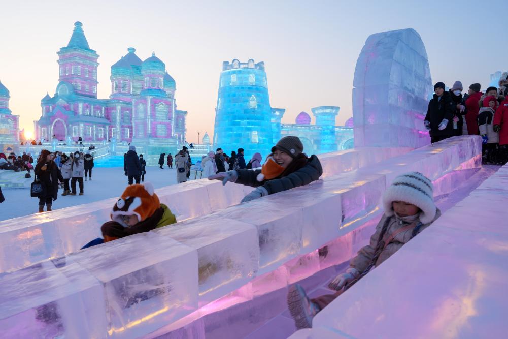 游客在哈爾濱冰雪大世界園區(qū)內(nèi)體驗(yàn)冰滑梯。新華社發(fā)