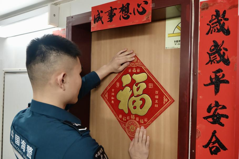 1月27日，在中國(guó)海警海鷗艦上，執(zhí)法員貼春聯(lián)福字慶祝農(nóng)歷春節(jié)。