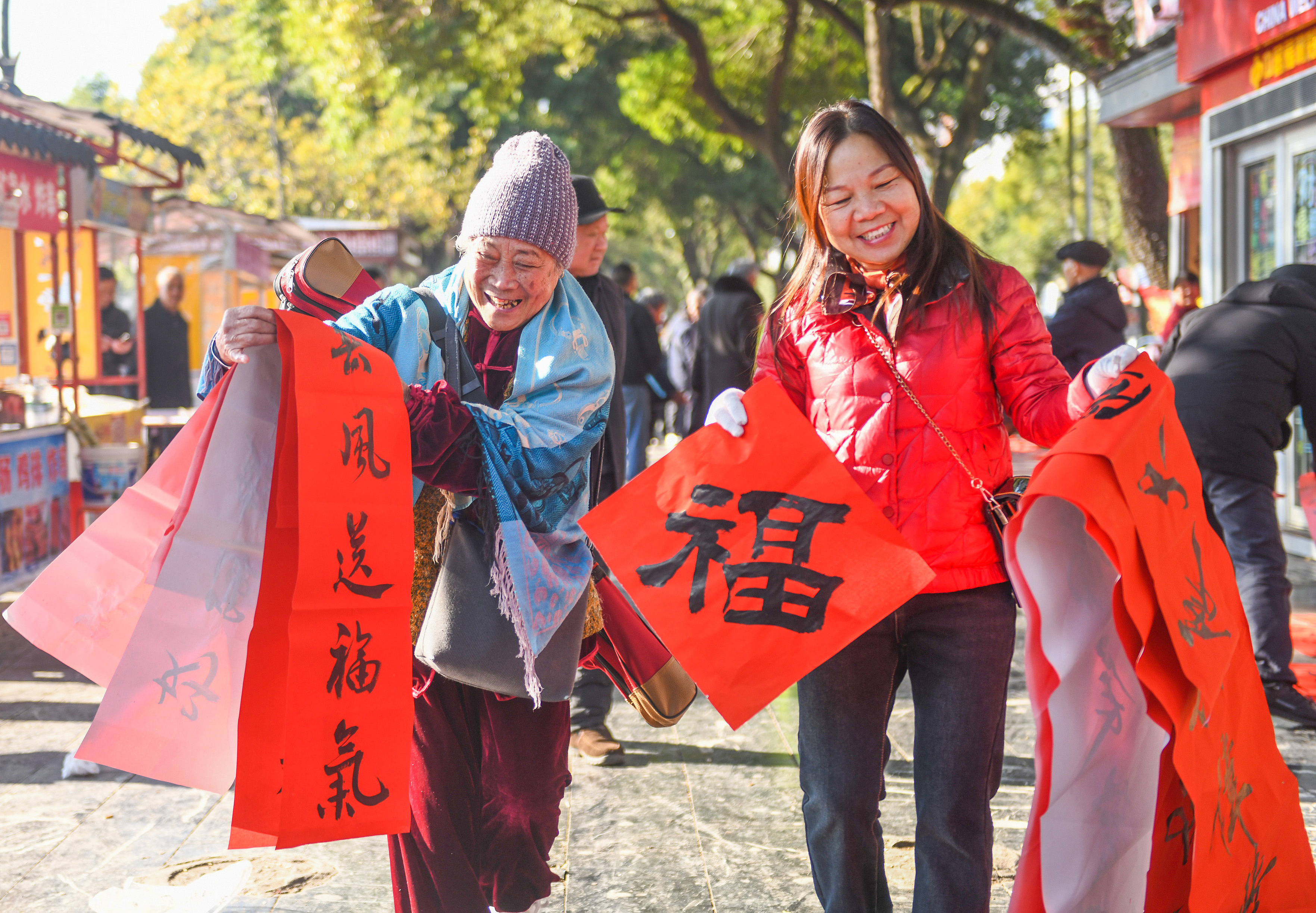 2025年1月13日，在湖南省永州市道縣西洲公園義工崗亭，市民們領到了書法志愿者為大家書寫的春聯(lián)。