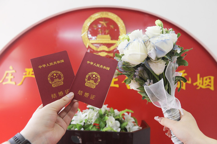 2024年8月10日，一對新人在河北石家莊新樂市民政局婚姻登記處領(lǐng)取結(jié)婚證后拍照留念。新華社發(fā)（賈敏杰攝）