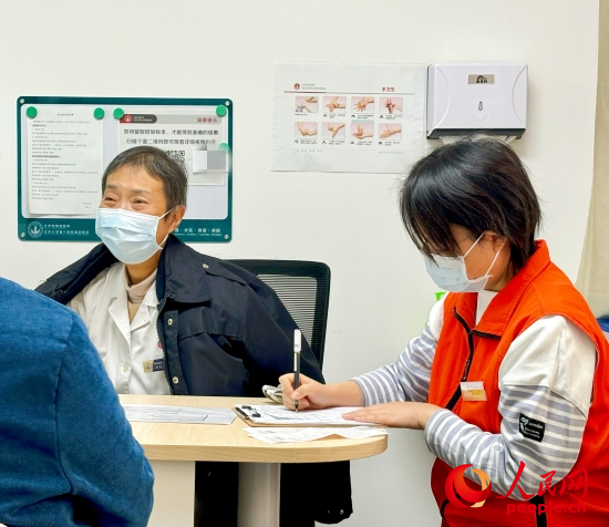 秦苑（中）接診患者。人民網(wǎng)記者 金慧慧攝