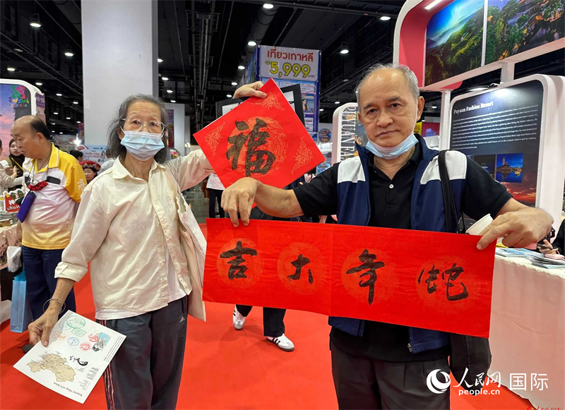 2025蛇年春節(jié)，泰國市民展示他們領(lǐng)到的華人手寫春聯(lián)。人民網(wǎng)記者 簡承淵攝