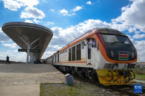 5月31日，在蒙內(nèi)鐵路內(nèi)羅畢站，機(jī)車駕駛員蔣立平（右）和博爾在即將開往蒙巴薩的E2次列車上揮手致意。新華社記者 楊光 攝